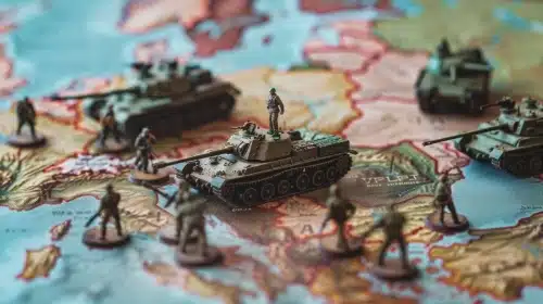 Figuras en miniatura de tanques y soldados posicionadas sobre un mapa antiguo, simbolizando conflictos geopolíticos