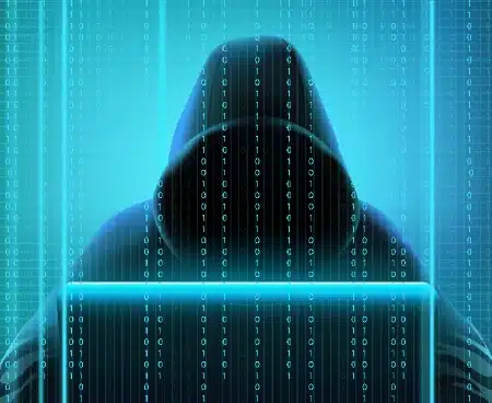 silueta de un hacker encapuchado frente a una computadora, envuelto en una estética digital.