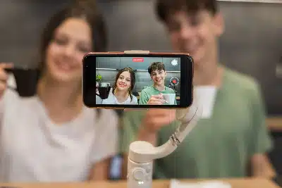 pareja joven grabando un video para redes sociales o un vlog, utilizando un smartphone montado sobre un estabilizador