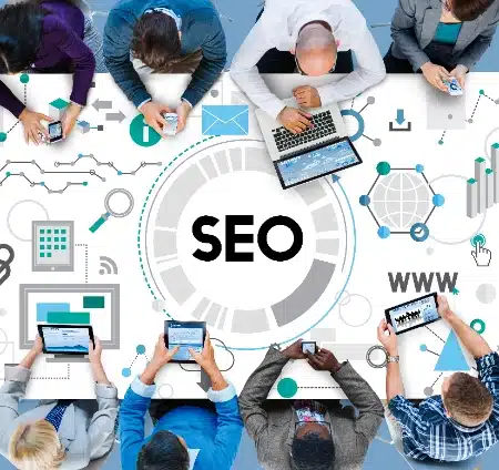 grupo de personas trabajando con diversos dispositivos tecnológicos alrededor de una mesa interactiva que destaca el concepto de SEO mediante una variedad de iconos de análisis, conectividad y marketing digital.